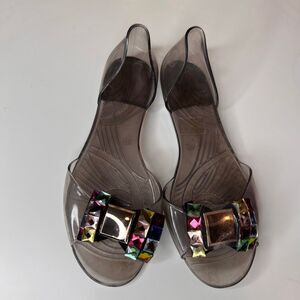 jelly flat sandals in a translucent smoke-gray color featuring large decorative